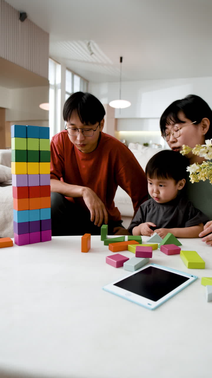 Family playing with wooden blocks and a tablet