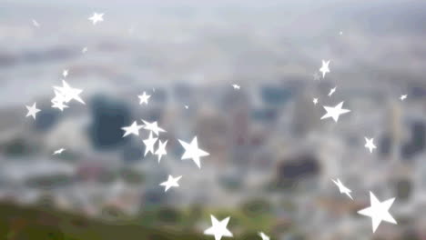 multiple star icons falling against aerial view of blurred cityscape