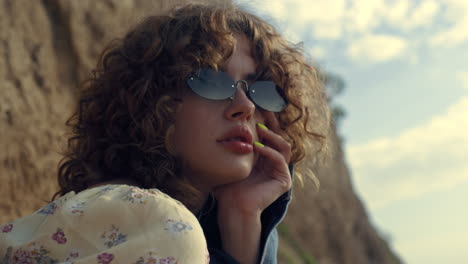 dreamy woman portrait sitting in sunglasses on seashore. lady enjoy last rays