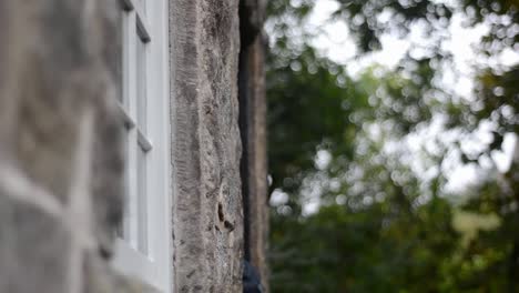 Woman-hiker-enters-and-exits-an-old-building-doorway-in-woodland