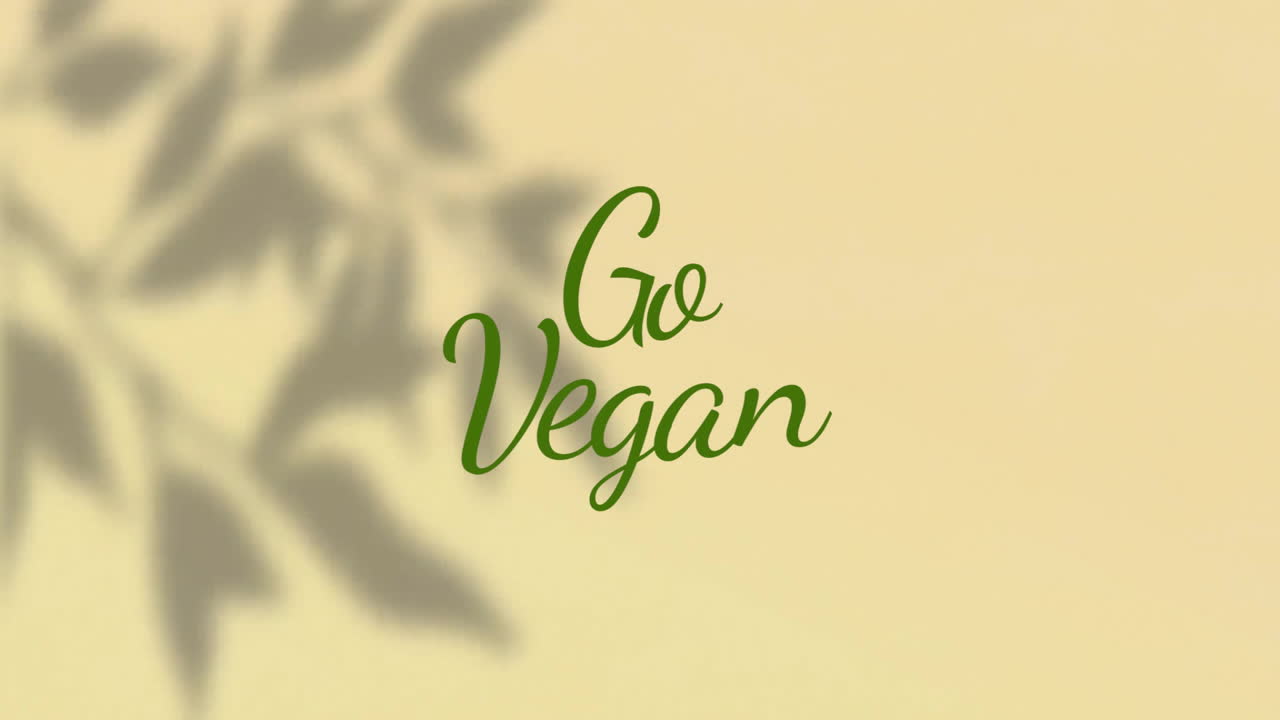 Animation of go vegan text over shadow of leaves on beige background