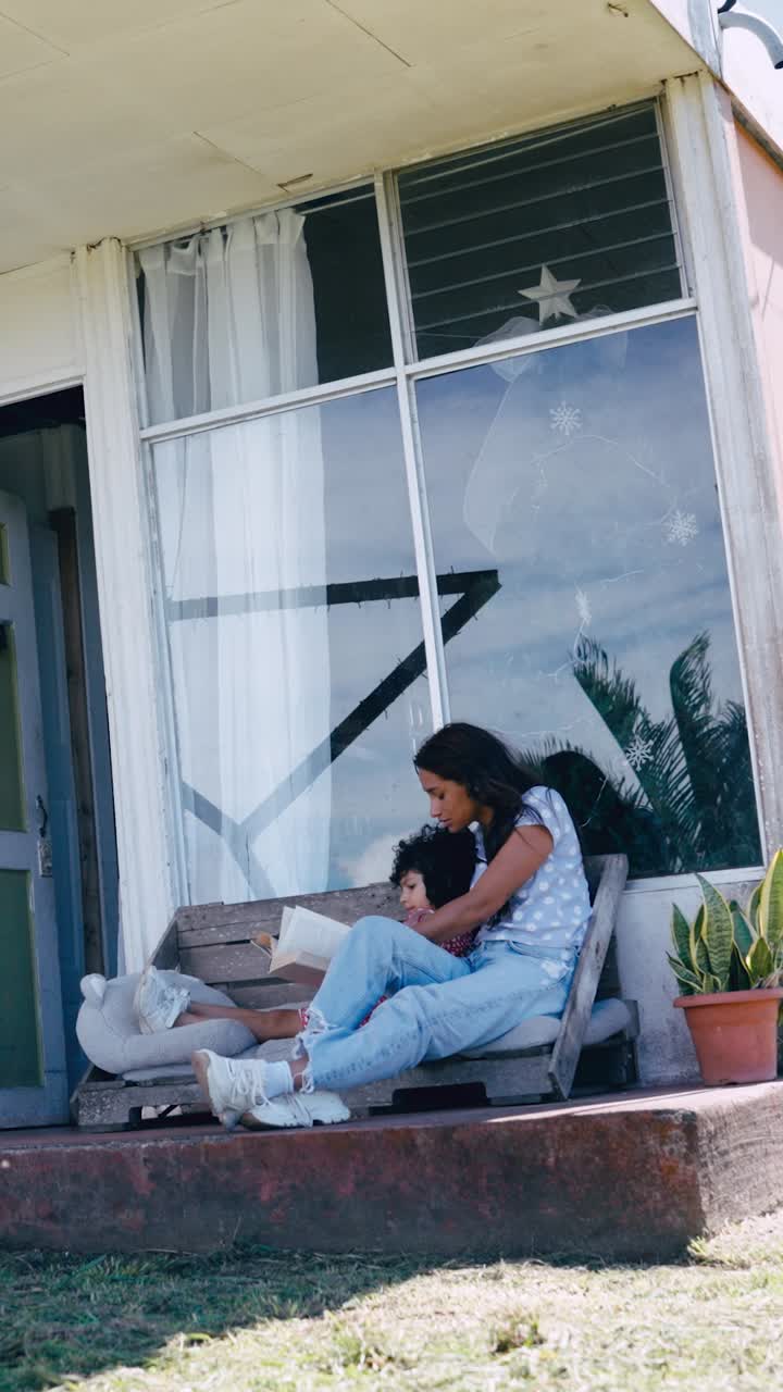 Madre e figlio che leggono un libro insieme su una panchina all'aperto