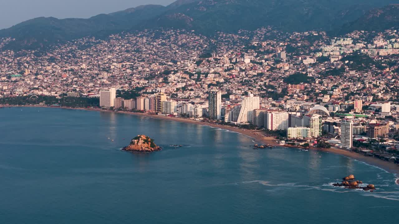 Drone footage showing Acapulco Bay under calm waters and clear skies, Mexico