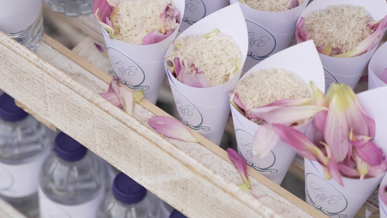 Paper cones filled with rice and pink flower petals ready for a wedding celebration toss