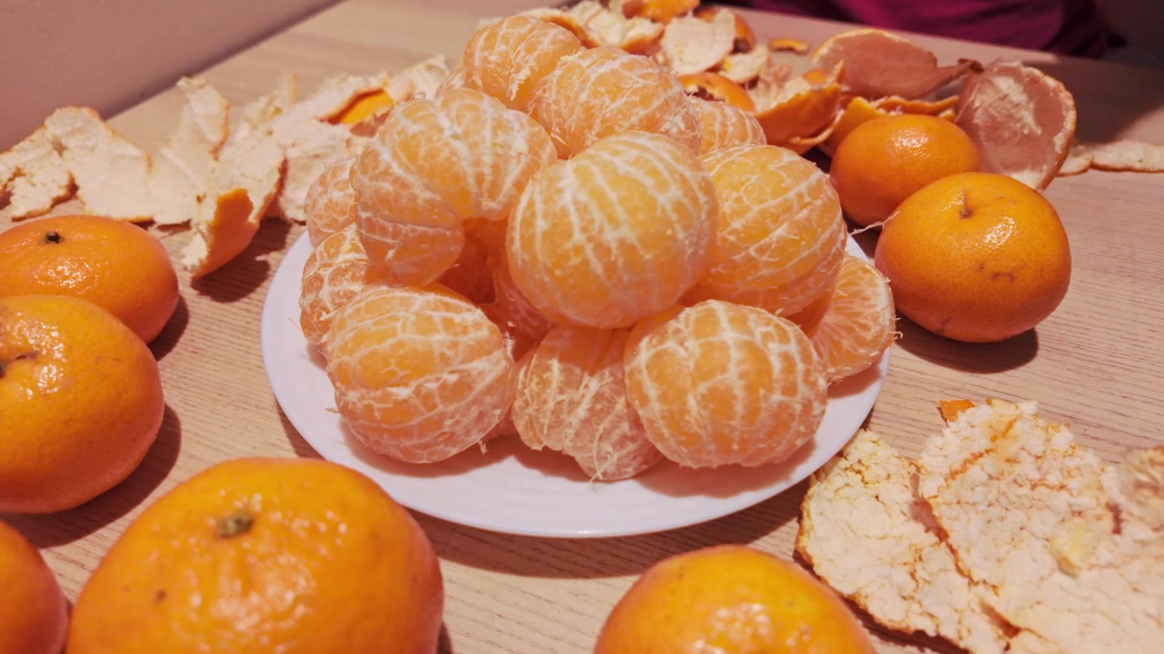 Timelapse menunjukkan tumpukan jeruk mandarin yang sudah dikupas yang terus bertambah, tersusun di atas piring