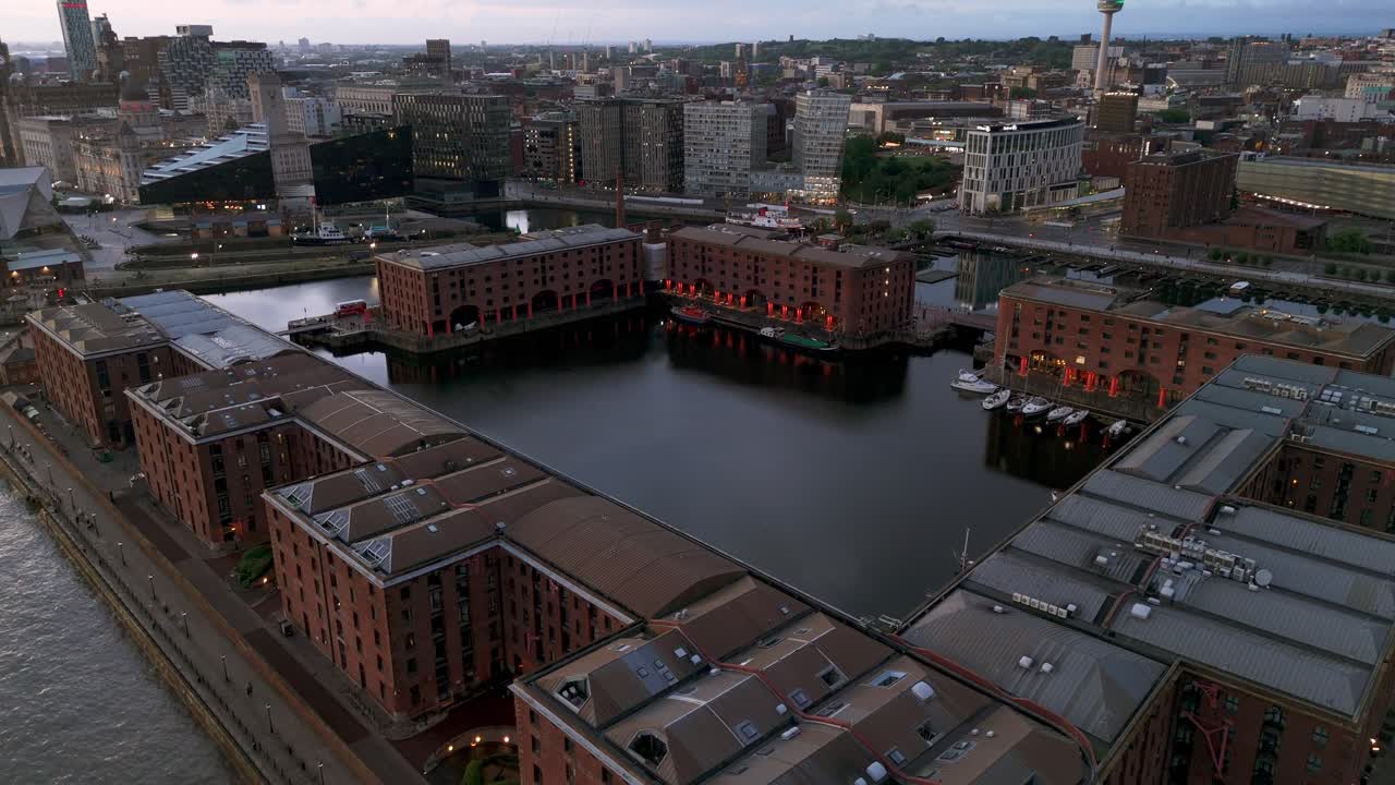 Royal Albert Dock at twilight. Illuminated warehouses and calm water of docks, Liverpool, UK. Aerial drone view