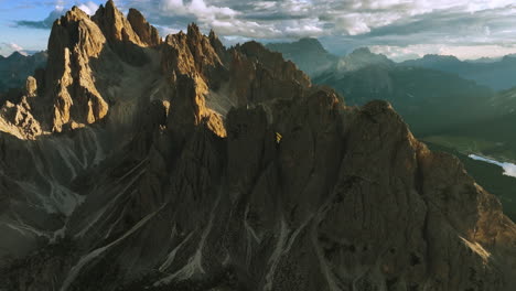 Aerial-view-following-the-Cadini-di-Misurina-massif,-golden-hour-in-Dolomites,-Italy---tilt,-drone-shot