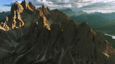 aerial view following the cadini di misurina massif, golden hour in dolomites, italy - tilt, drone shot
