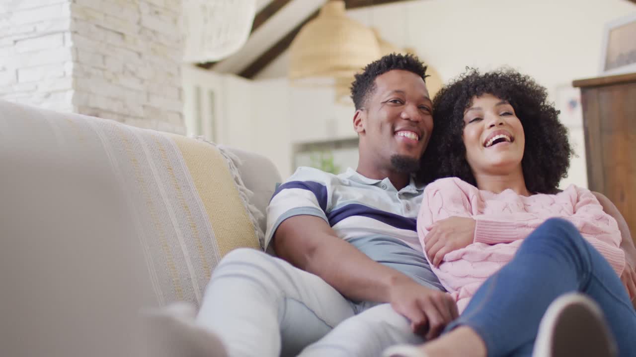 Happy african american couple embracing together in living room