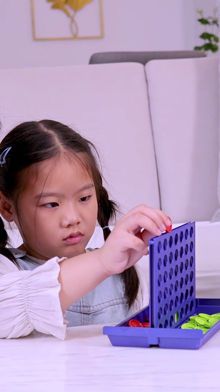 Bambino concentrato sul posizionamento dei pezzi del gioco, ambiente interno, illuminazione soffusa, primo piano, angolazione della telecamera stabile.