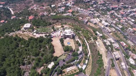 Tiro-De-órbita-Alta-Del-Antiguo-Castillo-Rodeado-De-Hermosos-Paisajes-Verdes,-Pueblo-De-Baissour,-Líbano