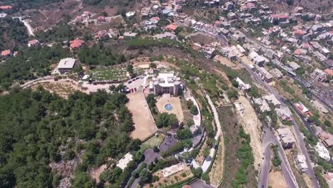 toma de órbita alta del antiguo castillo rodeado de un hermoso paisaje verde, pueblo de baissour, líbano