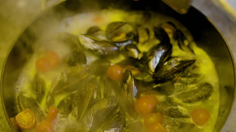 el cocinero cocina mejillones en la sartén 1