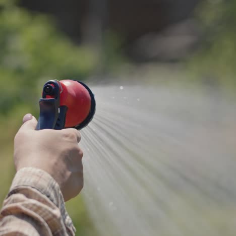 Gardener-sprays-water-from-a-garden-hose-4