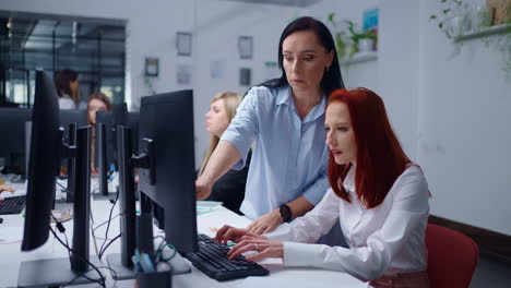 dos mujeres trabajando juntas en un escritorio en una oficina