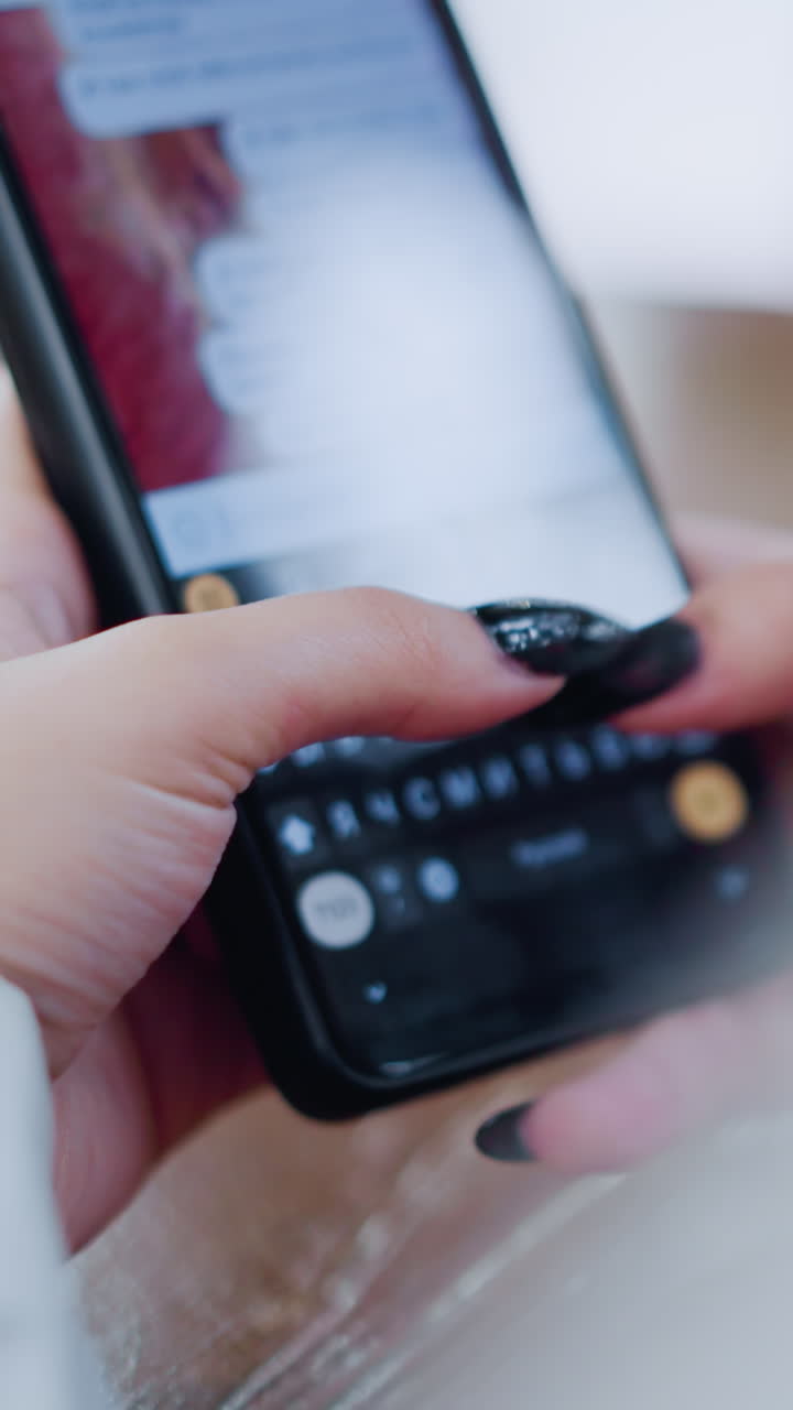 primer plano de un teléfono móvil negro utilizado por una mujer para chatear, manos escribiendo en la pantalla, colocado en una mesa de madera con un efecto de luz borrosa vibrante en el fondo