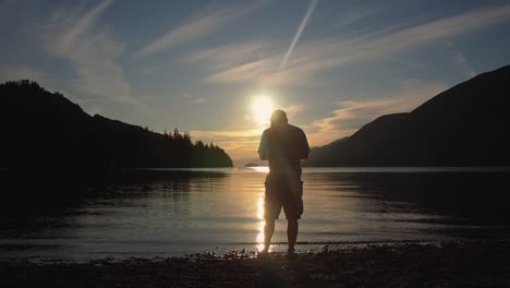 sunset-with-mountains-clouds-and-man-taking-a-picture-in-background