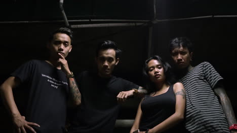 low angle portrait of four young asian adults, posing with a serious and tough demeanor.