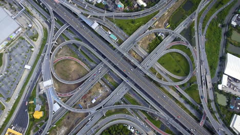 vista aérea del cruce de carreteras con tráfico urbano ocupado que acelera en la carretera