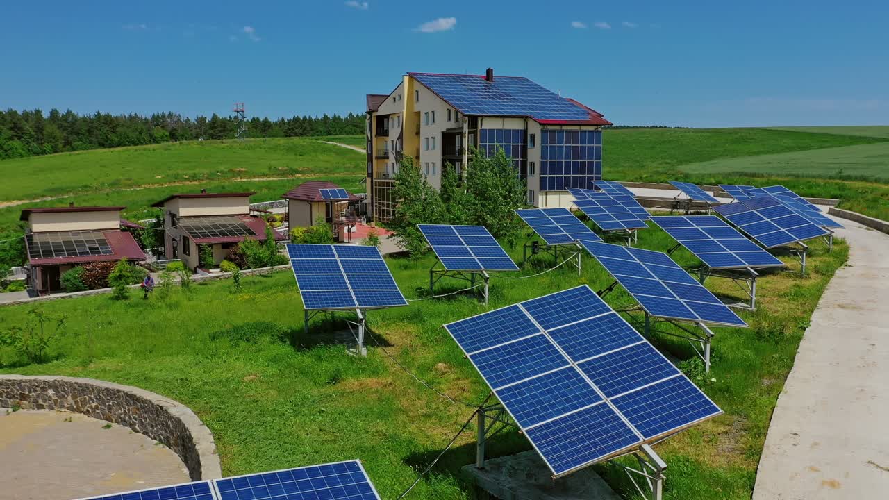 Solar panels on field. Modern architecture among nature with sunny batteries on roof and outer wall. Renewable source of clean energy.