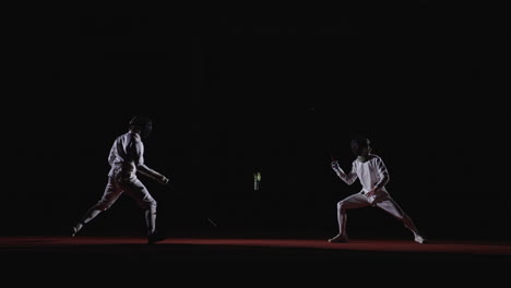 two fencers in action during a competition