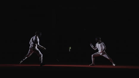 dos esgrimistas en acción durante una competencia