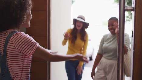 diverse group of happy female friends greeting hugging together