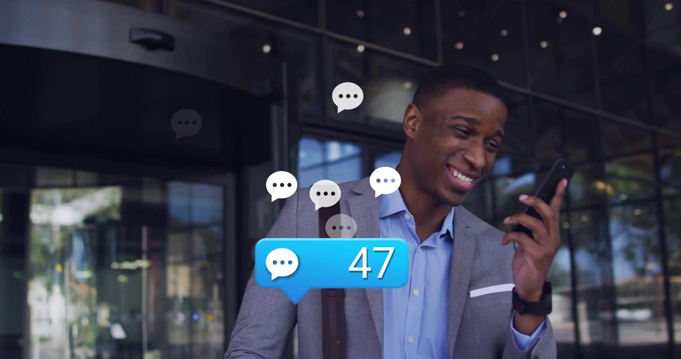 Businessman outside office holding call, watching animated message bubbles rising, celebrating win
