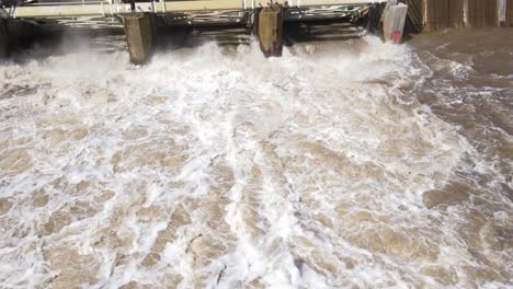 Splashing-water-falling-from-dam-in-Michigan,-aerial-view