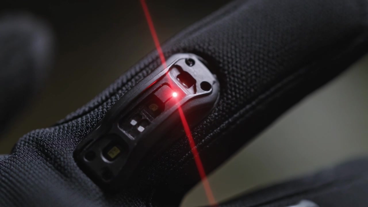 Aktiverer laser, taktisk handske fingerspidsmodul sporer bevægelig rød prik i nærbillede for justering.