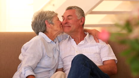 Senior-couple-sitting-on-couch-talking-together