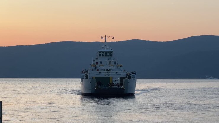 Large ferryboat docked in sea at sunset