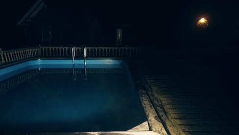 Slow-motion-Pool-illuminated-at-night-From-the-water-is-steam