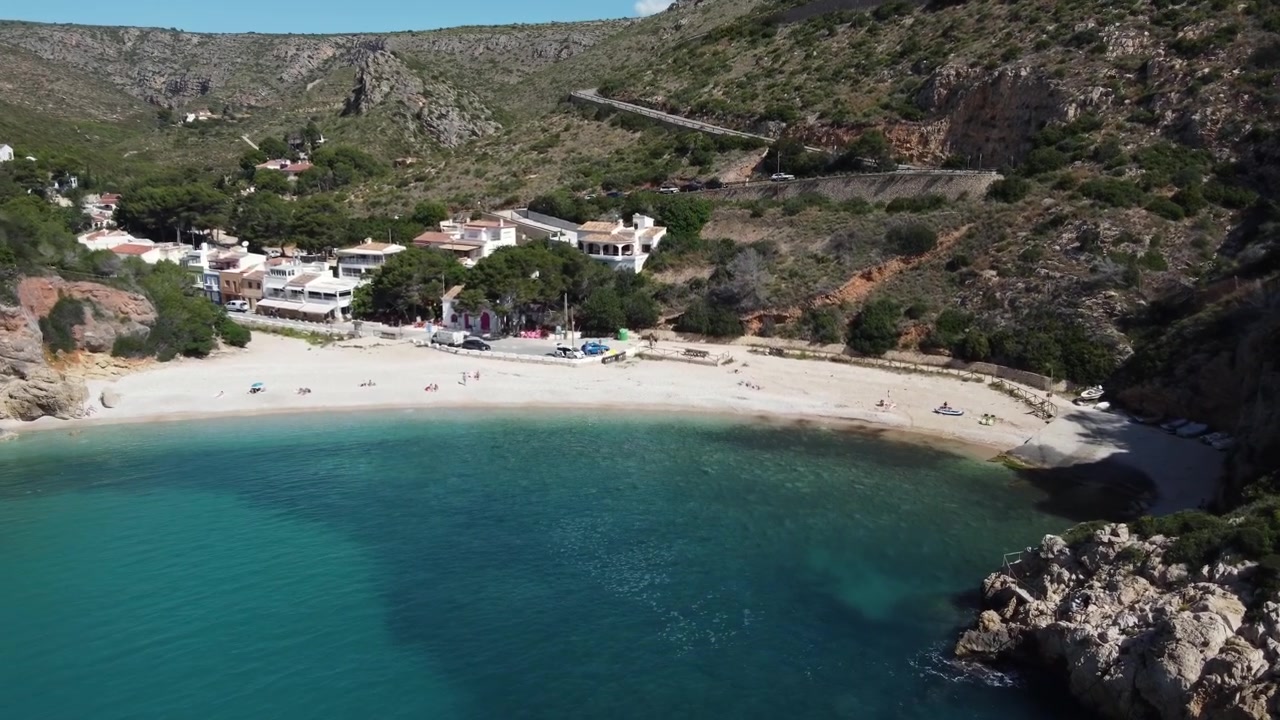 Letecký pohled na bílý písek pláže Granadella, Javea, Španělsko.