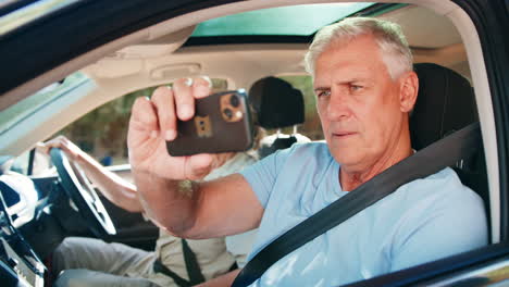 Un-Pasajero-Toma-Una-Foto-Con-Un-Teléfono-Móvil-Mientras-Una-Pareja-De-Ancianos-Disfruta-De-Una-Excursión-De-Un-Día-En-Coche