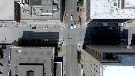 Intersección-En-El-Centro-De-Davenport,-Iowa-Con-Tráfico-En-Movimiento-Y-Establo-De-Video-De-Drones