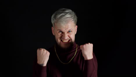 overjoyed young man wins competition achieves goal and makes triumph gesture, says yes, shows fist