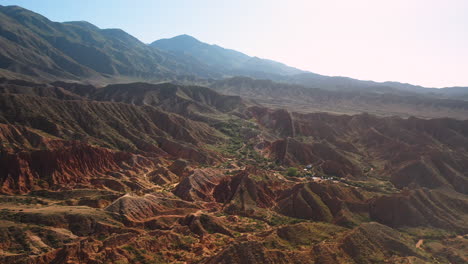 cinematic revealing drone shot flying over mountain ridges at fairy tale canyon near issyk-kul lake in karakol, kyrgyzstan