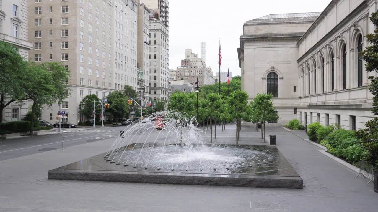 The circular fountain in front of New York City's Metropolitan Museum of Art as seen from the museum entrance steps, offering a serene cityscape