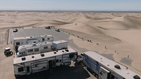 Land-of-Leisure,-Aerial-Drone-Shot-of-Glamis-California-Weekend-Warriors-by-Parked-RV's-and-Trailers-on-Sunny-Desert-Day