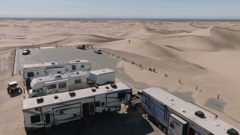 tierra de ocio, toma aérea de drones de guerreros de fin de semana de glamis california por vehículos recreativos y remolques estacionados en un día soleado en el desierto