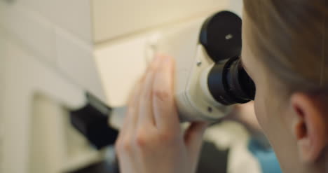 scientist examining bacteria under microscope at laboratory