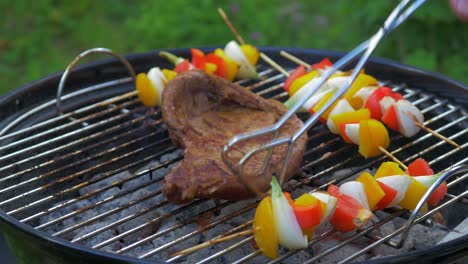 flank steak mixed with vegetables on a skewer being grilled over hot coals