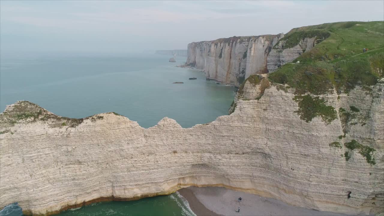 Aerial view of the dramatic white chalk cliffs of Étretat in Normandy, France, rising above turquoise waters of the English Channel