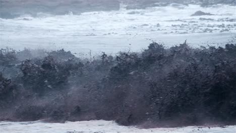 Wall-of-black-water-with-debris-crashing-through-onto-the-shore