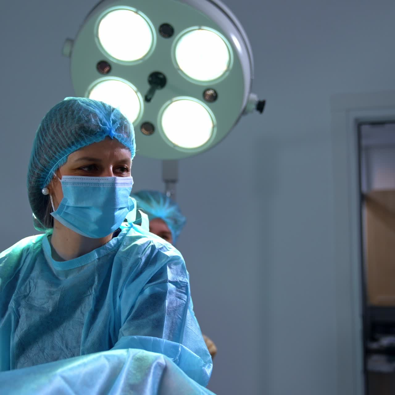 Female gynecologist performing the check up for a woman. Doctor in mask looks at the ultrasonic image and comments