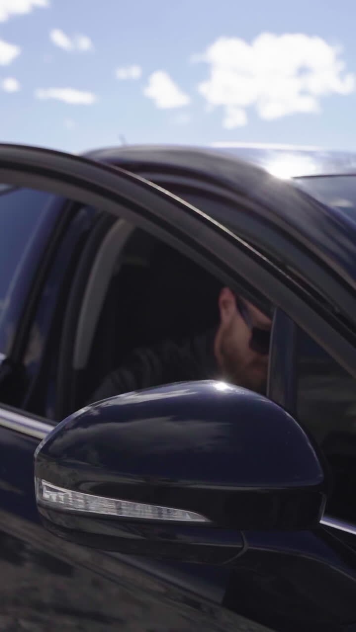 Uomo affascinante e rude in auto. Giovane uomo casual che scende da un'auto di lusso.
