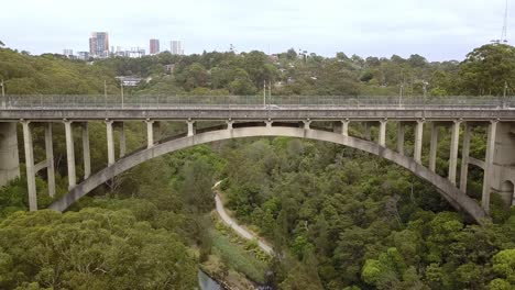 vista lateral del largo puente colgante de gully con tráfico en el área de northbridge de sydney, australia, toma aérea de drones