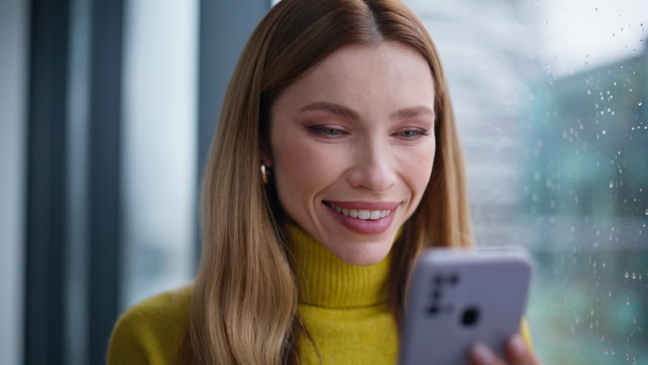 Woman hands sending sms by smartphone in apartment closeup. Smiling lady