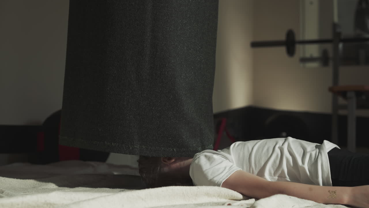 스포츠 센터에 누워있는 아이의 머리를 숨기는 시 가방: 옷의 가장자리는 전투 체육관에서 작은 소녀의 얼굴을 닫습니다.